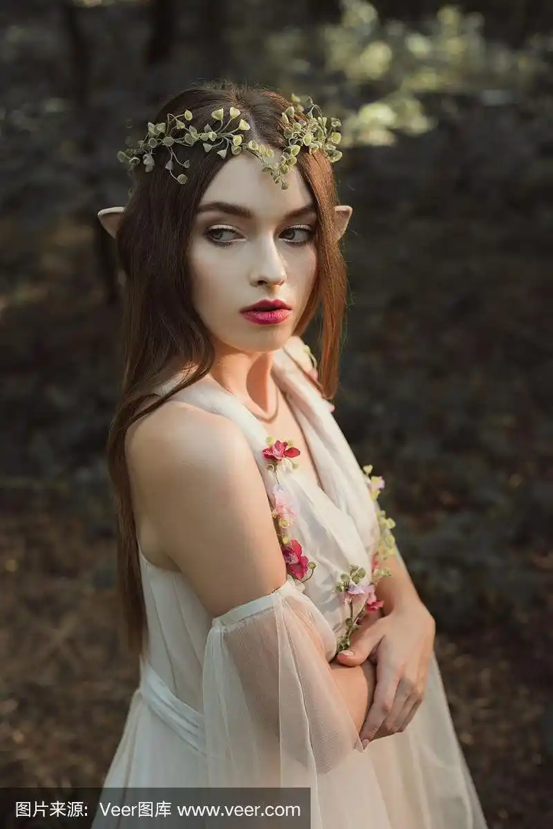 美丽的女精灵穿着鲜花和花环,双臂交叉站在森林里