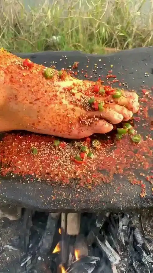 这哥们饿疯了吧,拿自己的脚烤着吃,不知道臭不臭!