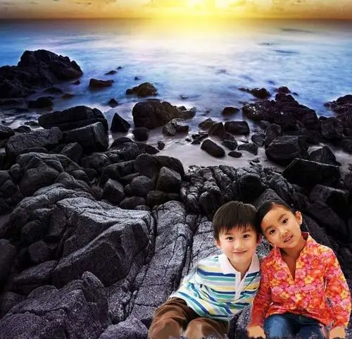 求图 两个小孩坐在海边的岩石上