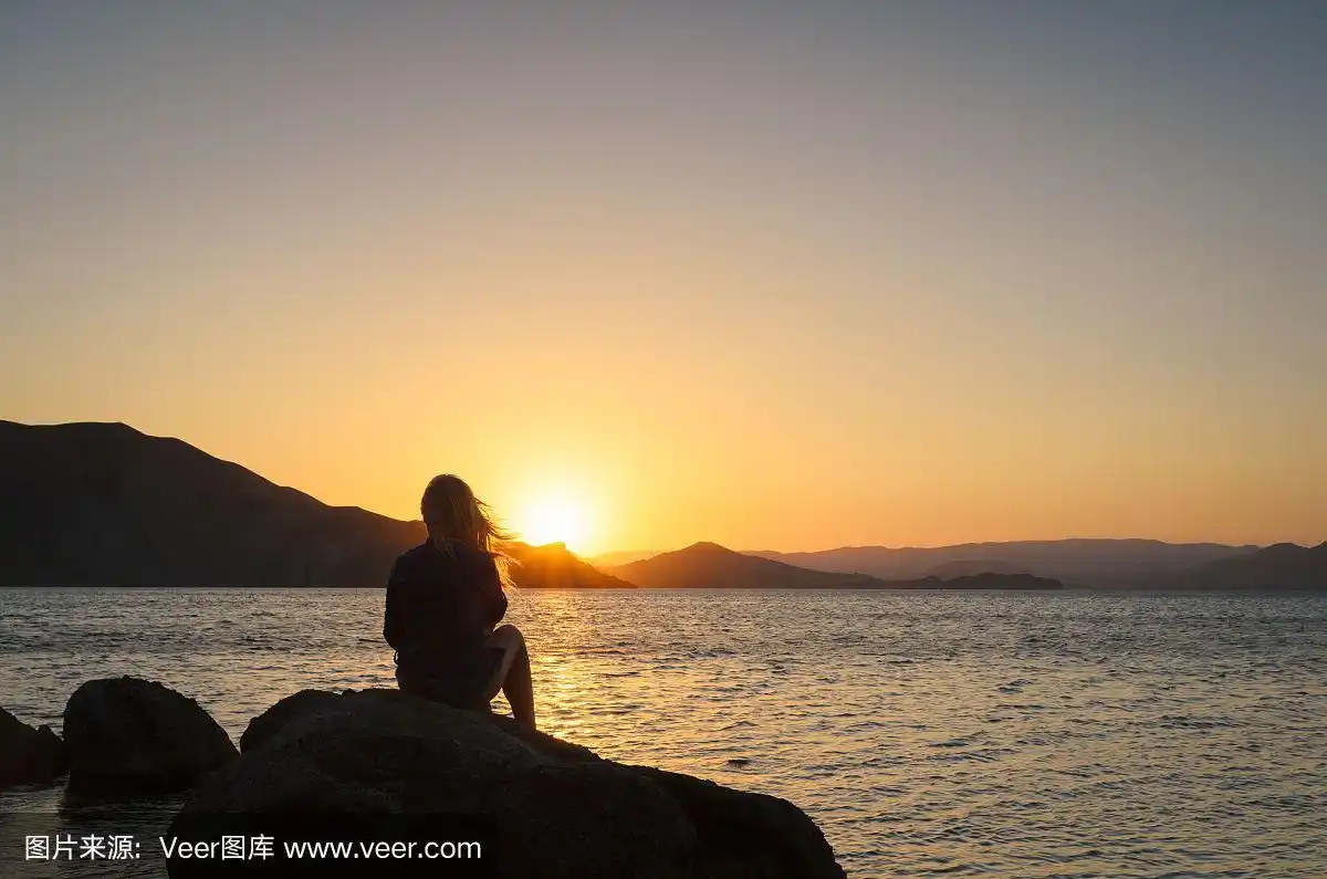 夕阳下海边的孤独女孩