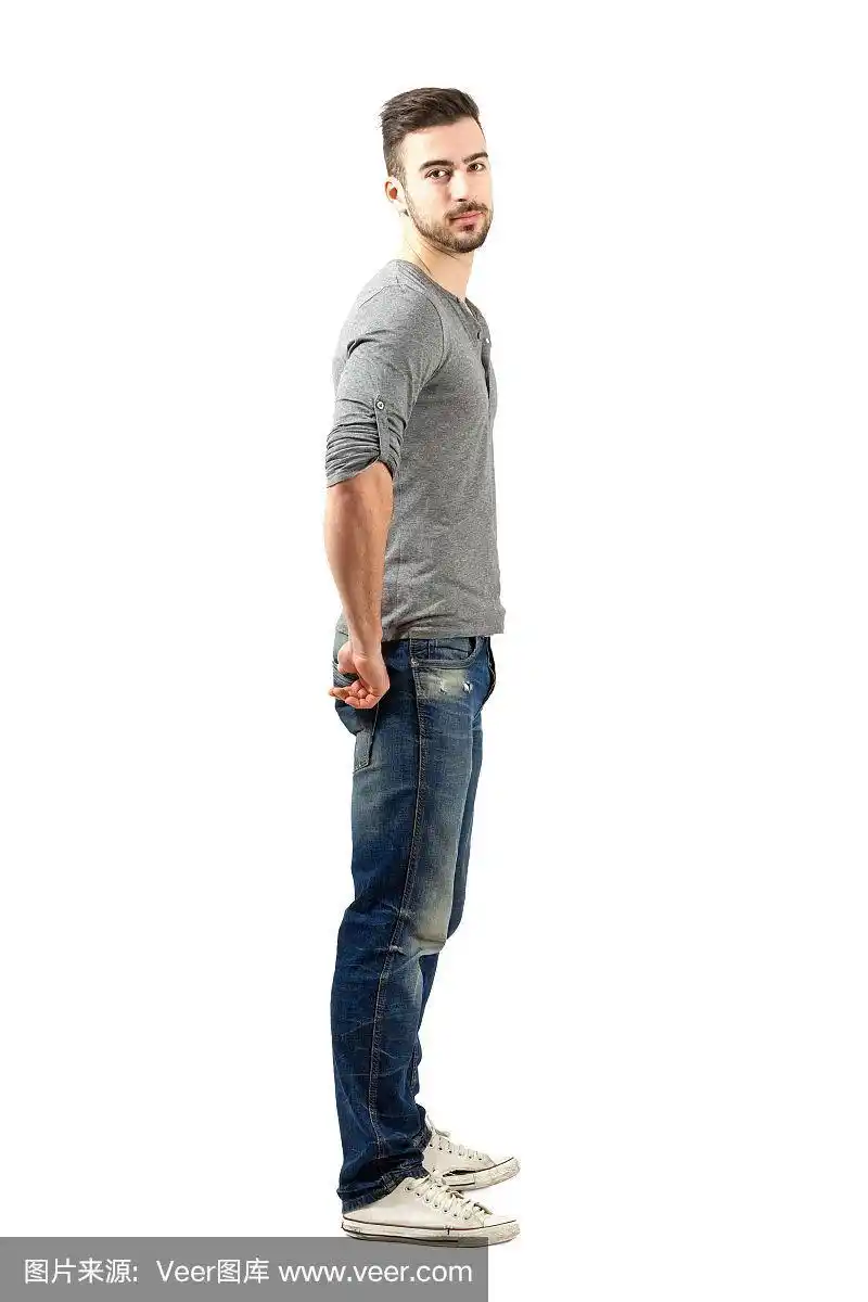 侧视图的年轻健康的家伙在牛仔裤和运动鞋