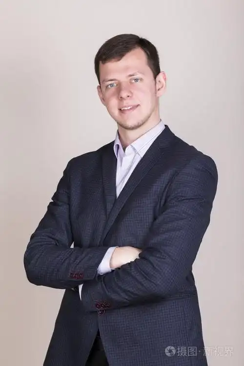 年轻成功的职业商人穿蓝夹克双手交叉