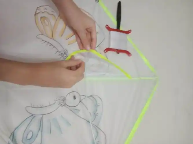 把风筝线穿入洞中.