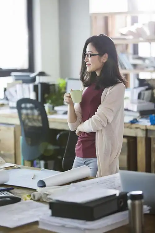 女建筑设计师在办公室喝咖啡放松