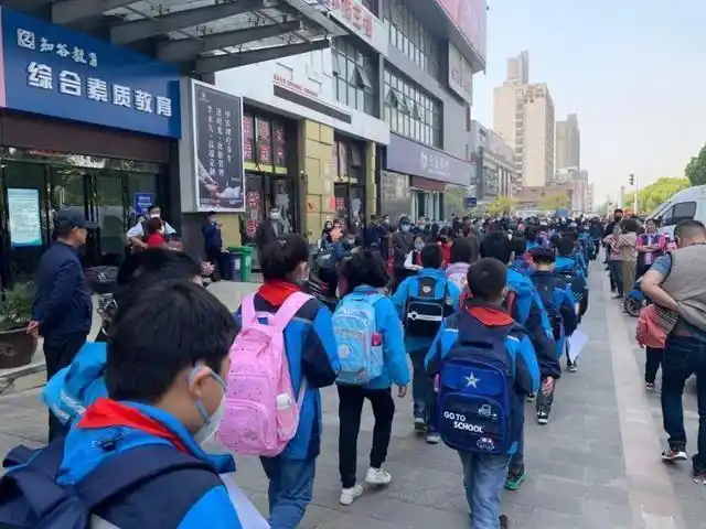 江苏南京:小学生放学像接机,某班请于e号口接,某班d号区请候