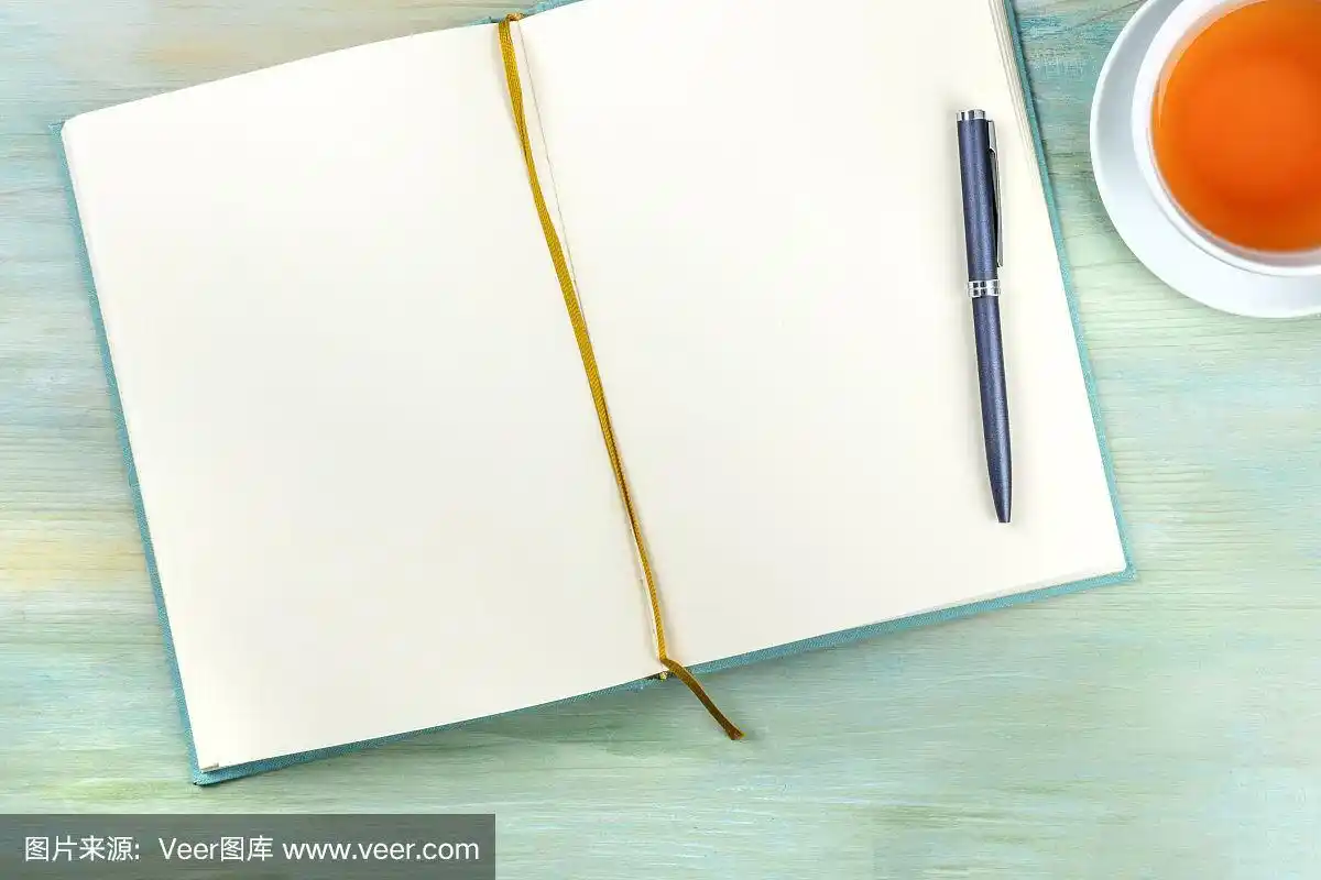 上面的照片是一个打开的日记本,一支笔和一杯茶,从顶部拍摄,日记在蓝