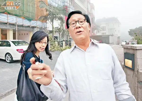 郑经翰去年在其山顶豪宅外,批评屋宇署选择性执法,后为其妻劳锦嫦.