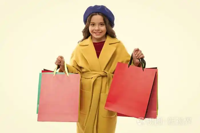 可爱的小女孩拿着一堆购物袋.孩子满足于购物孤立的白色背景.