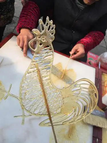 2017年1月30日,浙江嘉兴,一位浇糖画民间艺人制作的"糖画鸡".