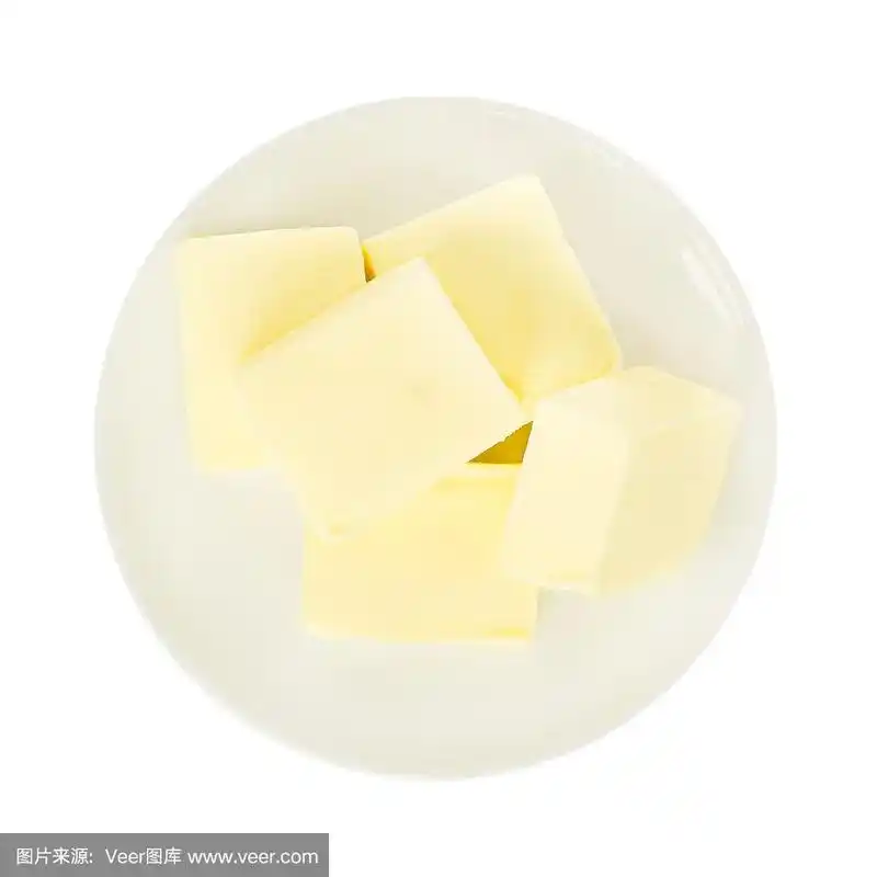 白色盘子上的新鲜黄油块的特写.在白色背景上单独放置黄油.