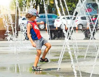 淋湿男孩快乐的孩子在喷泉里玩水照片